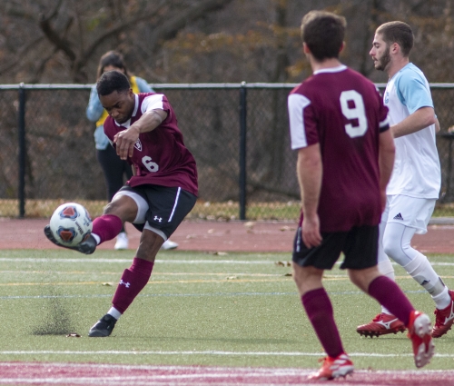 male soccer player kicks ball 